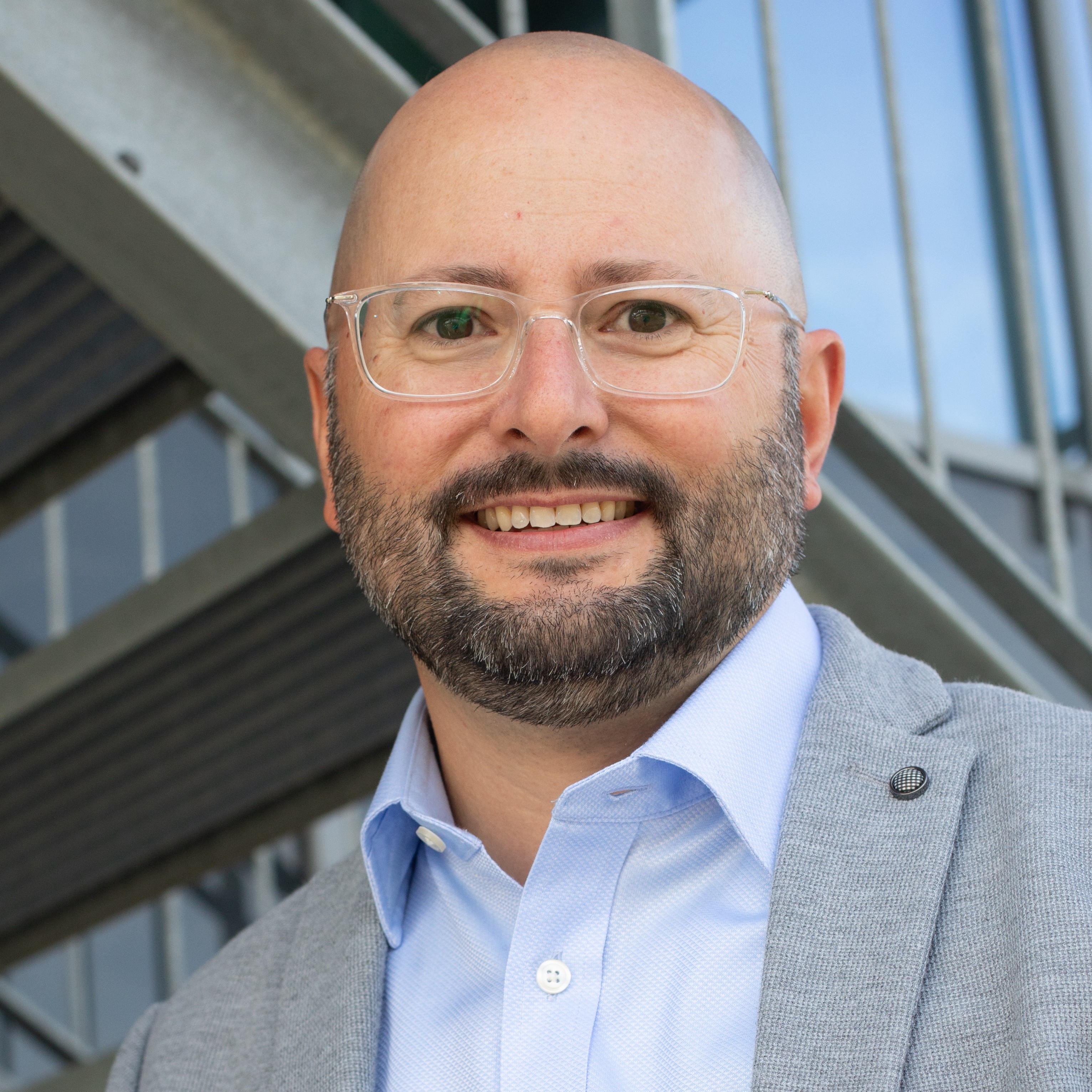 Dr. Jens Träger, professionelles Portrait im hellgrauen Sakko und Hemd.